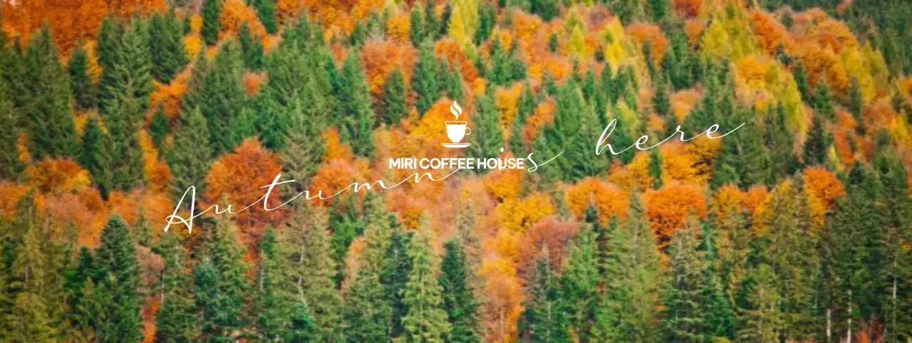 Fall-inspired cafe with cursive accents against a mountain backdrop filled with colorful fall leaves.