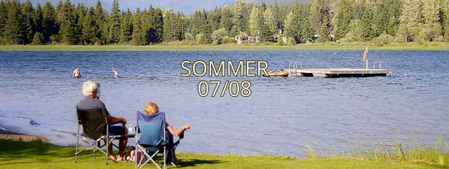 Werbung für das Fotocafé eines älteren Paares oberhalb eines Seeparks im Sommer