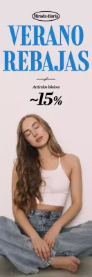 Modelo de ropa sentado en el suelo con fondo gris