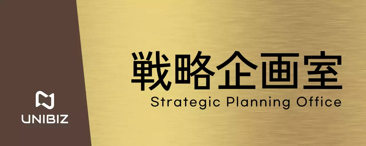 茶色と黒の企業会社名、部署名と正方形の図形があるシンプルな場所案内板